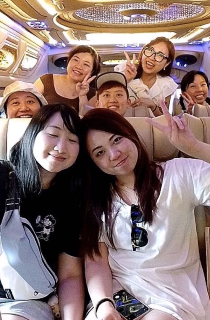 A tour group smiling together in the van