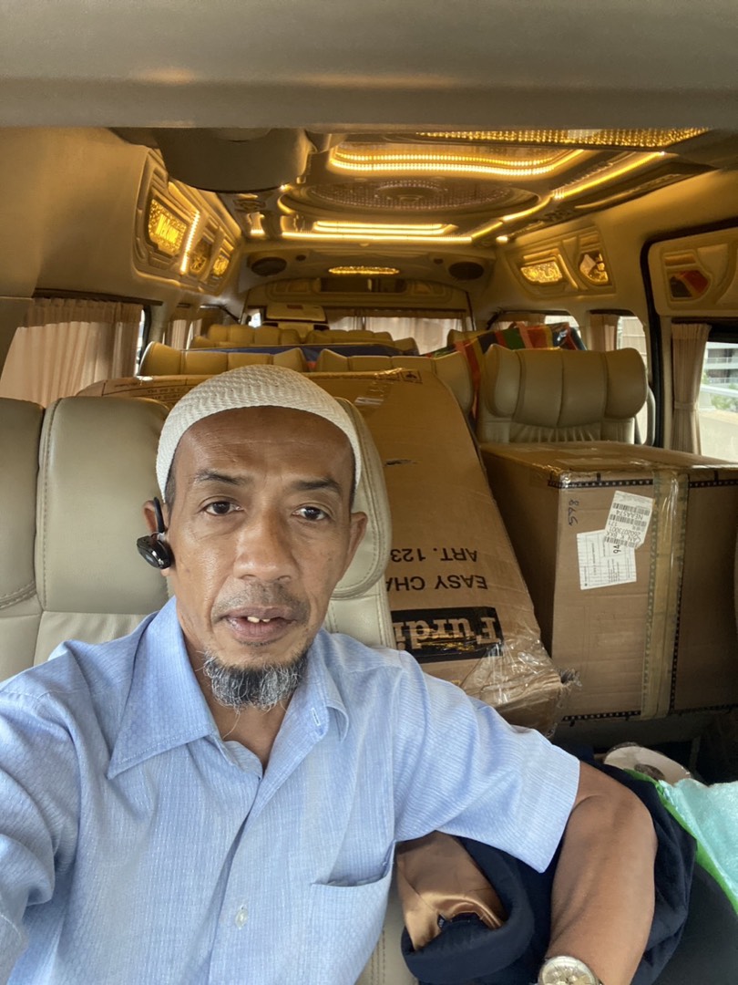 Sonny, the driver, inside his van wearing a headset, ready to take a booking